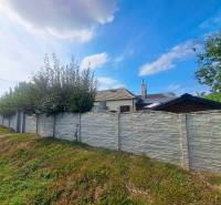 Domov, kde si vytvoríte vlastný príbeh – rodinný dom na predaj, Neded - Rodinný dom v Nedede s kamenným plotom a upravenou záhradou pod modrou oblohou.