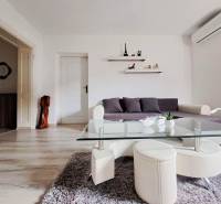 Domov, kde si vytvoríte vlastný príbeh – rodinný dom na predaj, Neded - Obývačka v rodinnom dome s pohovkou, skleneným stolíkom a podlahou s dreveným dekorom.