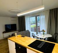 5 - izbový rodinný dom - 168 m², na pozemku 223 m², Ivanka pri Dunaji - Kuchynský ostrovček s varnou doskou, jedálenský stôl a pohovka v rodinnom dome.