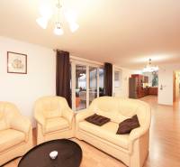 ViNi real / TOP PONUKA! Moderný 4-izb. bungalov s garážou, KVETOSLAVOV - Obývačka rodinného domu s krémovou sedačkou a podlahou s dreveným dekorom.