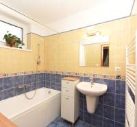 Investičná príležitosť v Kvetoslavov - DOM ideálny pre súkromnú škôlku - Kúpeľňa v rodinnom dome s vaňou, umývadlom, dlaždicami a oknom s kvetinou.