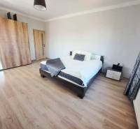 Exkluzívne na predaj 5 izbový rodinný dom - Spálňa v rodinnom dome s posteľou, šatníkovou skriňou a podlahou s dreveným dekorom.