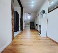 Exkluzívne na predaj 5 izbový rodinný dom - Interiér rodinného domu s podlahou s dreveným dekorom a schodiskom v pozadí.