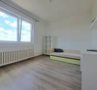 Exkluzívne na predaj 5 izbový rodinný dom - Svetlá izba s poličkami, rozkladacou posteľou a oknom v rodinnom dome, podlaha s dreveným dekorom.