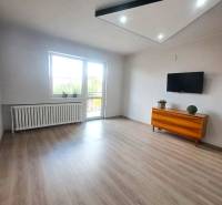 Exkluzívne na predaj 5 izbový rodinný dom - Obývačka v rodinnom dome s podlahou s dreveným dekorom, televíziou a komodou.