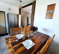 Exkluzívne na predaj 5 izbový rodinný dom - Jedálenský stôl s doplnkami a chladnička v kuchyni rodinného domu.