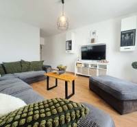 Exkluzívne na predaj 5 izbový rodinný dom - Obývacia izba v rodinnom dome s podlahou s dreveným dekorom a pohodlnou sedacou súpravou.