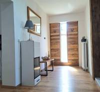 Exkluzívne na predaj 5 izbový rodinný dom - Interiér s drevenými vstupnými dverami a podlahou s dreveným dekorom v rodinnom dome.