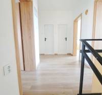 Exkluzívne na predaj 5 izbový rodinný dom - Interiér rodinného domu s podlahou s dreveným dekorom a bielymi dverami.