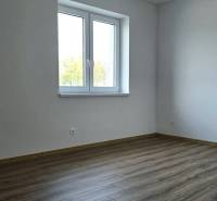 Moderný nízkoenergetický 4-izbový rodinný dom, Cífer – Karlov Dvor - Izba v rodinnom dome s podlahou s dreveným dekorom a bielymi stenami.