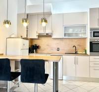 Trogir, Čiovo – pekný, zariadený apartmán len 150m od pláže - Kuchyňa v rekreačnom apartmáne s barovým pultom, závesnými svietidlami a bielou skríňou.