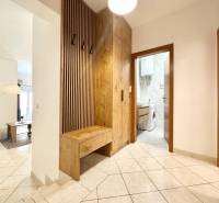 Trogir, Čiovo – pekný, zariadený apartmán len 150m od pláže - Chodba rekreačného apartmánu s práčkou a vešiakovou stenou s dreveným dekorom.