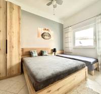 Trogir, Čiovo – pekný, zariadený apartmán len 150m od pláže - Svetlá spálňa s dreveným nábytkom, dvojposteľou a obrazom v rekreačnom apartmáne.