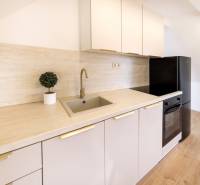  REZERVOVANY-PRENAJOM | NOVÝ 2 i. podkrovný byt v novostavbe - Kuchyňa v 2-izbovom byte s podlahou s dreveným dekorom a moderným vybavením.