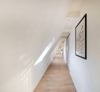  REZERVOVANY-PRENAJOM | NOVÝ 2 i. podkrovný byt v novostavbe - Chodba v 2-izbovom byte s podlahou s dreveným dekorom, strešným oknom a obrazom na stene.