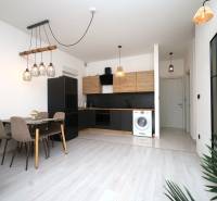 Vodice – novo zrekonštruovaný dvojspálňový apartmán s výhľadom na more - Kuchyňa v rekreačnom apartmáne s jedálenským stolom a podlahou s dreveným dekorom.