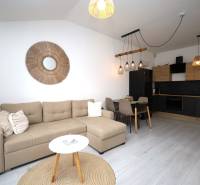 Vodice – novo zrekonštruovaný dvojspálňový apartmán s výhľadom na more - Obývačka v rekreačnom apartmáne s kuchyňou, pohovkou a dekoratívnym prvkami na stene.