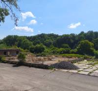 Pozemok o rozlohe 1880 m2  vo Veľkom Krtíši. - Pozemky - komerčné na Lučeneckej ceste vo Veľkom Krtíši s opustenou stavbou, obklopené stromami.