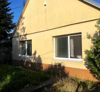 Znížená cena  4-izbový rodinný dom s veľkým pozemkom len 5min od Šale - Rodinný dom v Diakovciach so šikmou strechou a žltou fasádou, obklopený zeleňou.