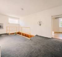 Rodinný dom vo vyhľadávanej obci Betliar. - Interiér rodinného domu s kobercom, schodiskom a jednoduchou dekoráciou na stene.