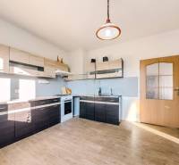 Rodinný dom vo vyhľadávanej obci Betliar. - Kuchyňa v rodinnom dome s podlahou s dreveným dekorom a modernými linkami.