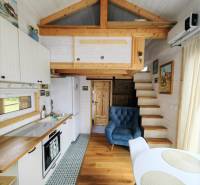 Tiny house - malý domček - Štýlová kuchyňa so sedacím kútom v rodinnom dome s podlahou s dreveným dekorom.