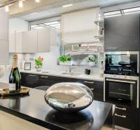 Predaj moderná 5 izbová vila, 265 m2, pozemok 953 m2, bazén,BA II. - Kuchyňa na ulici Imelová a Vila, čierne skrinky, biela linka, okno, dekorácie, kvety.