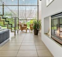 Predaj moderná 5 izbová vila, 265 m2, pozemok 953 m2, bazén,BA II. - Obývačka má krb, schody, čierny gauč; výhľad na ulicu Imelová, Vila a záhrada.
