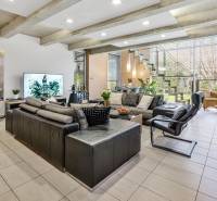 Predaj moderná 5 izbová vila, 265 m2, pozemok 953 m2, bazén,BA II. - Obývačka s veľkým oknom, pohodlnými sedačkami a schodiskom; pohľad na záhradu.