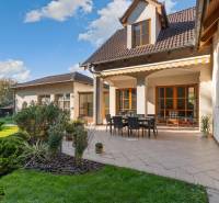 Predaj luxusná 5 izbová Vila,440 m2,pozemok 1061m2,garáž,bazén,BA II. - Vila na ulici Hrušovská s terasou, záhradkou, obdĺžnikovým stolom a stoličkami pod markízou.