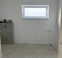 Novostavba- 4-izbový rodinný dom-Super Cena - Prázdna miestnosť v rodinnom dome s dreveným dekorom a úzkym oknom na stene.