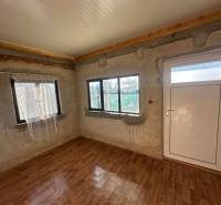 PREDAJ : ZÁHRADA S MUROVANOU CHATKOU, KOMÁRNO - Interiér s podlahou s dreveným dekorom a bielymi dverami v časti Záhrady.