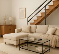 Na predaj ubytovňa / rodinný dom  v Šali  Veči s kapacitou 50 osôb - Interiér budovy s béžovou pohovkou, schodiskom a podlahou s dreveným dekorom.