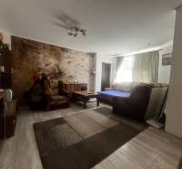 Rodinný dom s prístavbou na  podnikanie – Tešedíkovo - Obývacia izba v rodinnom dome s pohovkou, kreslami a nástennou maľbou za sedením.