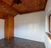 CHATKA SO ZÁHRADOU, PREŠOV – ŠIDLOVEC - Interiér chaty s bielymi stenami, dreveným stropom a podlahou s dreveným dekorom.