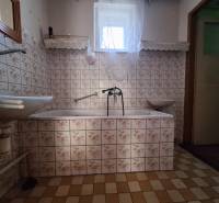 Výborný rodinný dom pre pohodlné bývanie - Kúpeľňa v Rodinnom dome s kachličkami s kvetinovým vzorom a vaňou.