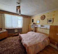 Výborný rodinný dom pre pohodlné bývanie - Spálňa v rodinnom dome s retro nábytkom, koberec a žlté tapety.