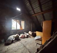 Predaj rodinného domu v Skalitom  - Podkrovná miestnosť s oknom v rodinnom dome plná starých predmetov a nábytku.