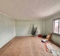 Predaj rodinného domu v Skalitom  - Izba v rodinnom dome s modrými tapetami, stromček, okno a uložené predmety.