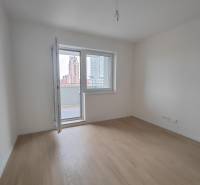  Na predaj moderný 2-izbový byt v Rezidencii Majakovského, Lučenec - Izba v 2-izbovom byte s podlahou s dreveným dekorom a balkónom.