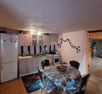 Hľadáte bývanie alebo investičnú príležitosť  - Kuchyňa v rodinnom dome s jedálenským stolom, kuchynskou linkou a chladničkou.