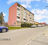 PRÍJEMNÝ 3 IZBOVÝ BYT | BOŠANY  - Ulica M. R. Štefánika v Bošanoch s bytovkou a zaparkovanými autami, vhodná pre 3-izbový byt.