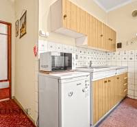 PRÍJEMNÝ 3 IZBOVÝ BYT | BOŠANY  - Kuchyňa v 3-izbovom byte s bielymi spotrebičmi, skrinkami a kachličkami.