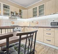 PRÍJEMNÝ 3 IZBOVÝ BYT | P.O.HVIEZDOSLAVA | TOPOĽČANY - Kuchyňa so svetlým nábytkom, jedálenským stolom a podlahou s dreveným dekorom v 3-izbovom byte.