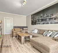 PRÍJEMNÝ 3 IZBOVÝ BYT | P.O.HVIEZDOSLAVA | TOPOĽČANY - Obývačka s rohovo umiestnenou sedačkou a podlahou s dreveným dekorom v 3-izbovom byte.