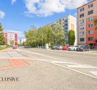 PRÍJEMNÝ 3 IZBOVÝ BYT | P.O.HVIEZDOSLAVA | TOPOĽČANY - Ulica P.O. Hviezdoslava v Topoľčanoch s bytovkami a zaparkovanými autami pri 3-izbovom byte.