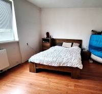 Investujte do budúcnosti - Spálňa v rodinnom dome s posteľou, komodou a podlahou s dreveným dekorom.