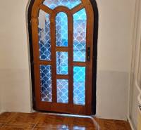 Investujte do budúcnosti - Klenuté drevené dvere so vzorovaným sklom v Rodinnom dome, podlaha s dreveným dekorom.