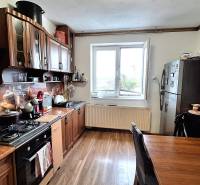 Investujte do budúcnosti - Kuchyňa rodinného domu s kuchynskou linkou, spotrebičmi a podlahou s dreveným dekorom.