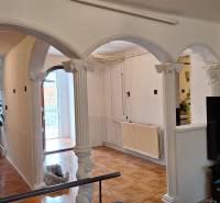 Investujte do budúcnosti - Interiér rodinného domu s oblúkovými stĺpmi a podlahou s dreveným dekorom.